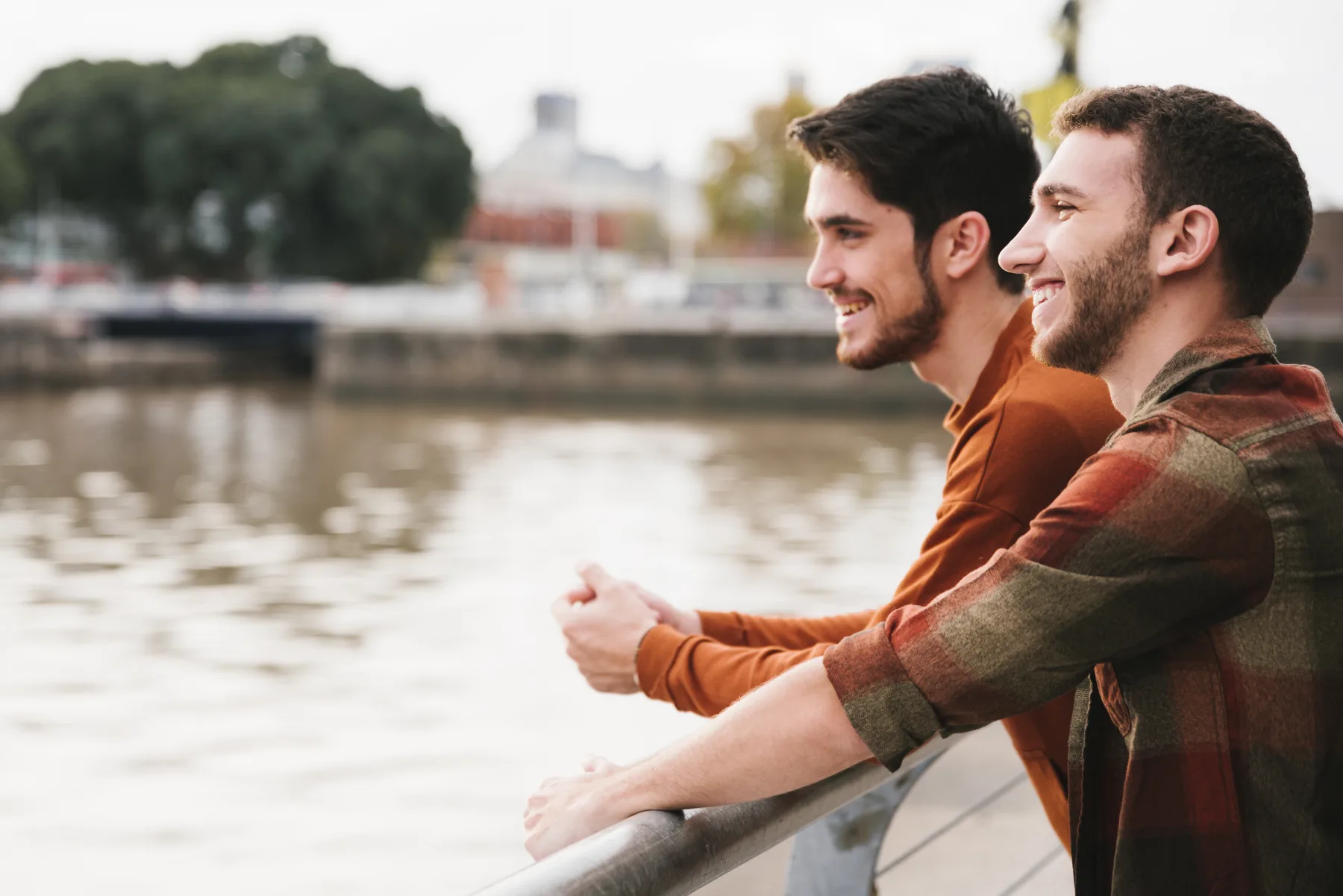 Two partners leaning together along a waterfront railing