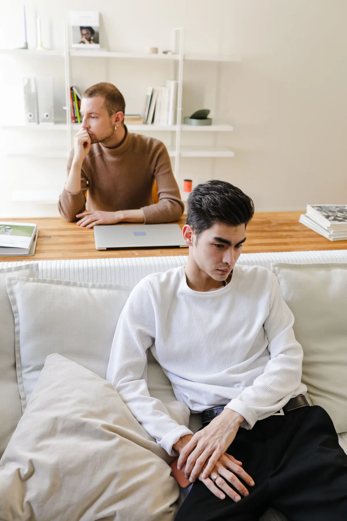 Two people in a quiet therapy-like setting, showing emotional distance and reflection.